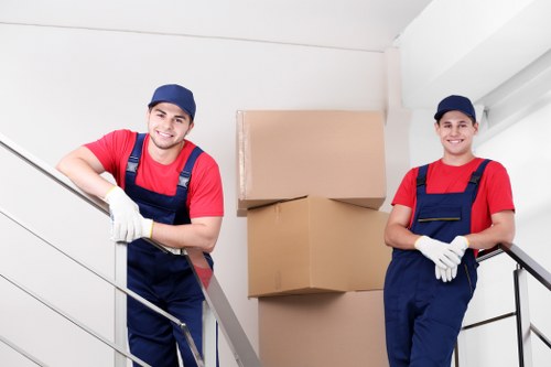 Professional movers carrying furniture through a residential building in Kennington